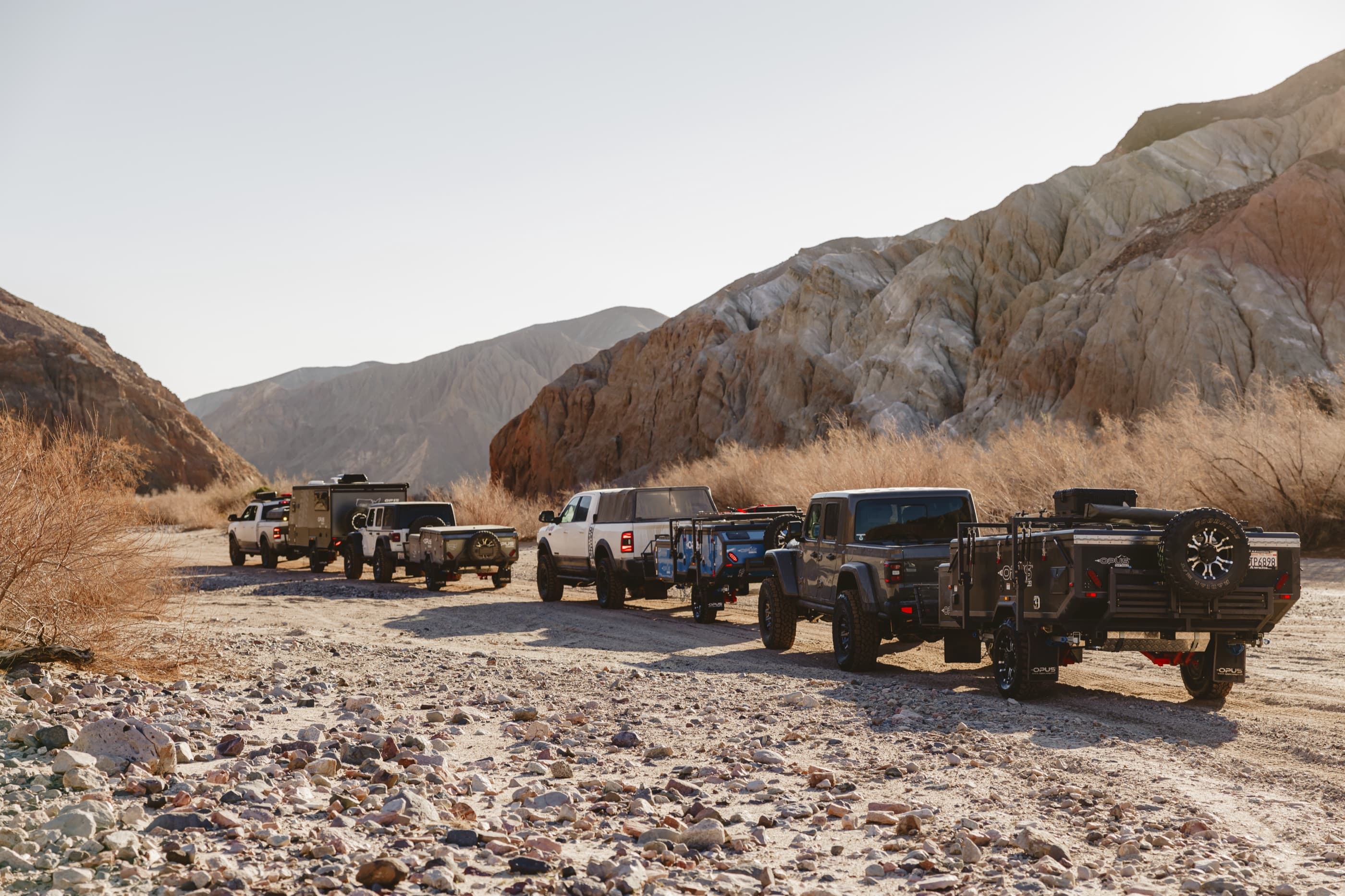 A convoy of OPUS campers on a canyon track